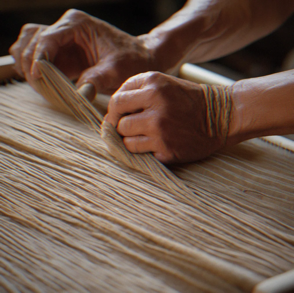 Close-up of woven fabric on the loom showing the natural fiber and tight weave